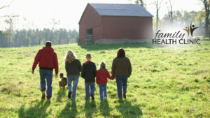 farming family walking in a field towards a red barn